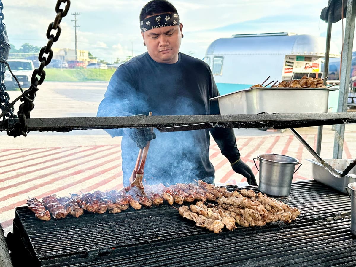 鉄板で串焼きを焼く屋台